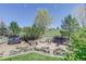 Expansive backyard featuring a patio with fire pit, trampoline, and mature trees for privacy at 12825 W 81St Ave, Arvada, CO 80005
