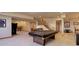 Finished basement features a pool table, living area, and stairway to upper level at 12825 W 81St Ave, Arvada, CO 80005