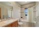 Well-lit bathroom with a tiled shower-tub combo and vanity, next to a commode at 12825 W 81St Ave, Arvada, CO 80005
