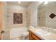 Well-lit bathroom showcasing tile accents, a tub, and a vanity with sink at 12825 W 81St Ave, Arvada, CO 80005