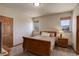 Cozy bedroom featuring natural light, a wooden bed frame, and a comfortable nightstand with a lamp at 12825 W 81St Ave, Arvada, CO 80005