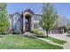 Beautiful two-story home with a manicured lawn, brick accents, and an inviting entrance with a large wooden door at 12825 W 81St Ave, Arvada, CO 80005