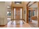 Inviting foyer boasts a beautiful wooden front door with glass sidelights and arched entryway leading to adjacent rooms at 12825 W 81St Ave, Arvada, CO 80005