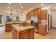 This open kitchen features a large island cooktop, stainless appliances, and hardwood floors at 12825 W 81St Ave, Arvada, CO 80005