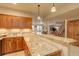 Open-concept kitchen featuring wood cabinets and granite countertops at 12825 W 81St Ave, Arvada, CO 80005