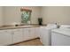 Functional laundry room featuring ample cabinet space, countertop, and a washing machine at 12825 W 81St Ave, Arvada, CO 80005