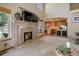 Cozy living room featuring a stone fireplace, large windows, and seamless access to the open kitchen at 12825 W 81St Ave, Arvada, CO 80005