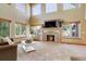 Bright living room featuring a stunning fireplace, large windows, and comfortable seating with lots of natural light at 12825 W 81St Ave, Arvada, CO 80005