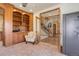 Cozy office with custom wood shelving, neutral carpet, and easy access to the staircase and hallway at 12825 W 81St Ave, Arvada, CO 80005