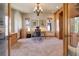 Well-lit office space featuring custom built-ins, a cozy carpet, and an elegant chandelier at 12825 W 81St Ave, Arvada, CO 80005