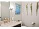 Stylish half bathroom with stone countertop, brushed gold faucet and decorative wall art at 14841 W Warren Ave, Lakewood, CO 80228