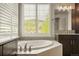 Bright bathroom features a soaking tub, dual sinks, and natural light from the window at 14841 W Warren Ave, Lakewood, CO 80228