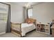 A bedroom featuring neutral walls, a chandelier, a window, and light wood furniture at 14841 W Warren Ave, Lakewood, CO 80228