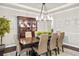 Stylish dining room with modern chandelier, hardwood floors, and large hutch provides a perfect space for entertaining guests at 14841 W Warren Ave, Lakewood, CO 80228