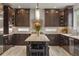 Spacious kitchen featuring custom dark wood cabinets, center island with bar stool seating at 14841 W Warren Ave, Lakewood, CO 80228