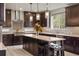 Gourmet kitchen featuring dark wood cabinets, a center island, and stainless steel appliances at 14841 W Warren Ave, Lakewood, CO 80228