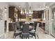 Eat-in kitchen with dark cabinetry, stainless appliances, tiled floors, and dining table set at 14841 W Warren Ave, Lakewood, CO 80228