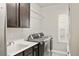 Bright laundry room with modern washer and dryer, window with shutters, and dark cabinets at 14841 W Warren Ave, Lakewood, CO 80228