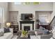 Cozy living room with fireplace, built-ins, and natural light from large windows at 14841 W Warren Ave, Lakewood, CO 80228