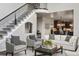 Bright living room with staircase, plush seating, and open floor plan to kitchen and dining area at 14841 W Warren Ave, Lakewood, CO 80228