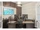 Well-appointed home office with built-in shelves offers a productive workspace, blending functionality with a professional aesthetic at 14841 W Warren Ave, Lakewood, CO 80228