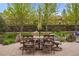Charming outdoor patio features a stone seating area, mature trees, and manicured landscaping at 14841 W Warren Ave, Lakewood, CO 80228