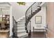 Grand staircase with dark wood railings and light carpet adds elegance to this home's sophisticated interior design at 14841 W Warren Ave, Lakewood, CO 80228