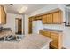 Bright kitchen with wood cabinets, an island with a double sink, and modern appliances at 20000 E Mitchell Pl # 34, Denver, CO 80249