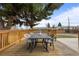Wooden back deck with dining table under the shade of a large pine tree at 7906 S Dover St, Littleton, CO 80128