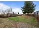 View of the backyard featuring green grass, a patio, a deck and a wooden fence at 7906 S Dover St, Littleton, CO 80128