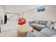 Finished basement featuring an orange chair, gray sofa, and view into a bedroom at 7906 S Dover St, Littleton, CO 80128