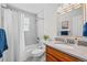 Bathroom featuring a shower-tub combo, wood vanity with hard surface countertop, and neutral wall coloring at 7906 S Dover St, Littleton, CO 80128