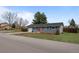 Charming ranch home featuring a red door, manicured lawn, and attached garage for convenient parking at 7906 S Dover St, Littleton, CO 80128