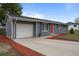 Attractive ranch home with a concrete driveway leading to the attached garage and blue window shutters at 7906 S Dover St, Littleton, CO 80128