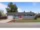 Well-maintained ranch-style home with a vibrant red door, neat landscaping, and an attached one-car garage at 7906 S Dover St, Littleton, CO 80128