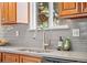 Close-up of the kitchen sink and counter, highlighting the fixtures, hardware, and tiled backsplash at 7906 S Dover St, Littleton, CO 80128