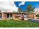 Charming brick home boasts a lush front yard with beautiful landscaping and an inviting entrance at 6005 W 39Th Ave # 6005, Wheat Ridge, CO 80033