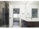 Modern bathroom with double vanity, sleek fixtures, and a glass-enclosed shower, leading to bedroom at 1898 S Bannock St # 505, Denver, CO 80223