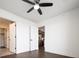 Open view from bedroom through doorway to kitchen area, with modern ceiling fan and wood floors at 1898 S Bannock St # 505, Denver, CO 80223