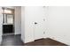 A small bedroom with dark hardwood floors and a doorway to a bathroom at 1898 S Bannock St # 505, Denver, CO 80223