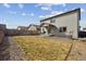 Exterior view of home from yard with patio, rock landscaping and dormant grass at 8852 Ventura St, Commerce City, CO 80022