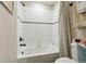 White tiled bathtub and shower combination featuring a shower curtain and bronze fixtures at 8852 Ventura St, Commerce City, CO 80022