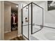 Modern bathroom featuring a glass enclosed shower, white tile, and view of closet space at 8852 Ventura St, Commerce City, CO 80022