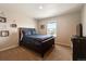 Comfortable bedroom with a window view, a wooden frame bed and furniture, and carpet flooring at 8852 Ventura St, Commerce City, CO 80022