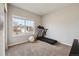 Neutral bedroom with a treadmill, workout equipment, and view to the neighborhood at 8852 Ventura St, Commerce City, CO 80022