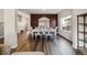Open-concept dining room with wood flooring, an accent wall, and view into living area at 8852 Ventura St, Commerce City, CO 80022