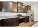Well-lit kitchen featuring stainless steel appliances, granite countertops, and sleek, dark wood cabinetry at 8852 Ventura St, Commerce City, CO 80022