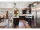 Kitchen with stainless steel appliances, dark cabinets, luxury vinyl plank flooring and granite countertops at 8852 Ventura St, Commerce City, CO 80022