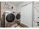 Laundry room with modern silver washer and dryer, white wire rack, and white closet at 8852 Ventura St, Commerce City, CO 80022