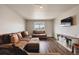 Comfortable living room featuring wood flooring, cozy seating, and a tv with modern storage at 8852 Ventura St, Commerce City, CO 80022